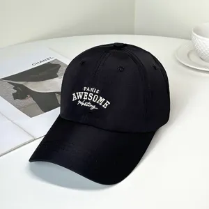 Close-up of black baseball cap featuring white PARIS AWESOME embroidered letter details