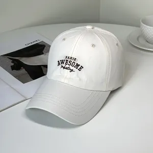 Close-up view of the detailed 'PARIS AWESOME' embroidery on a white fashion baseball cap