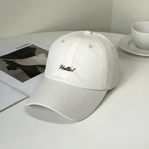 Detailansicht einer weißen Baseballkappe mit schwarzer 'Hello!'-Stickerei auf der Vorderseite.