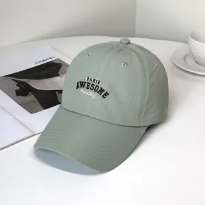 Close-up detail of light green quick-dry baseball cap with Paris Awesome embroidery.
