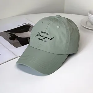 Close-up detail of black New York embroidery on a sage green quick-dry fashion baseball cap