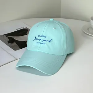 Close-up detail of a mint green baseball cap with navy blue New York embroidery