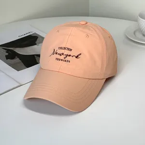 Detailed view of peach quick-dry baseball cap with New York letter embroidery