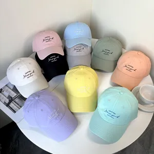 Collection of colorful embroidered baseball caps with 'New York' text on a table.