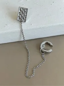 Vue détaillée d'une boucle d'oreille intégrée en argent avec clou floral et manchette à chaîne