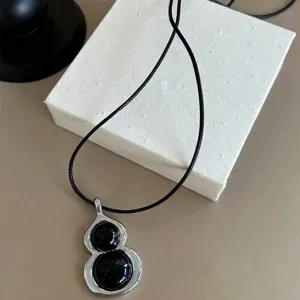 Minimalist black onyx gourd pendant necklace with long leather cord for unisex vintage style.