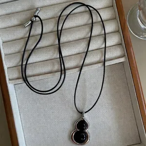 Elegant black agate gourd pendant on a minimalist black leather cord long necklace
