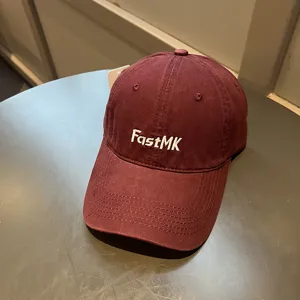 Primer plano detallado de una gorra de béisbol granate con bordado blanco FastMK de calidad