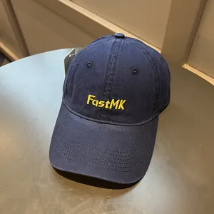 Vista detallada del bordado amarillo FastMK en una gorra clásica de algodón azul marino.