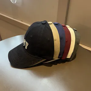 Vista lateral detallada de gorras de béisbol bordadas apiladas en varios colores.