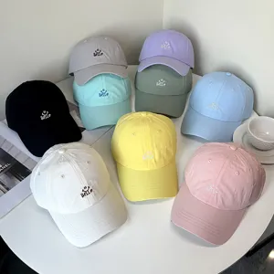 Detailansicht der bunt bestickten Baseballkappen mit einem süßen Hello-Smiley-Design