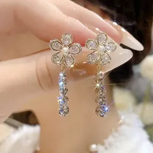 Detailed close-up of sparkling flower tassel earrings with shimmering crystals