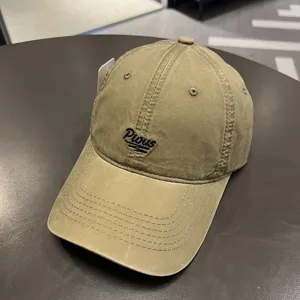 Dettaglio ravvicinato di un cappellino da baseball kaki lavato con ricamo Pious blu.