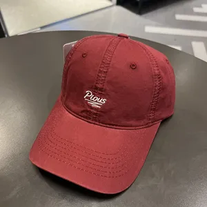 Dettaglio di un cappellino da baseball in cotone lavato bordeaux con ricamo Pious bianco