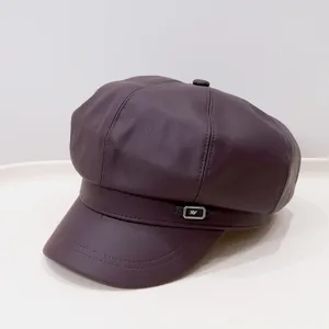 Macro detail of a vintage deep purple PU leather newsboy cap with metal logo accent