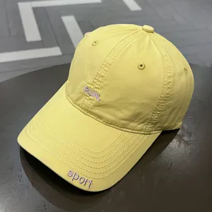 Dettaglio di un berretto da baseball in cotone lavato giallo con ricamo RUN viola