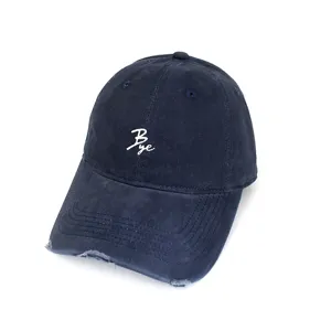 Close up of the dark blue baseball cap featuring white embroidered letter detail and distressed brim.