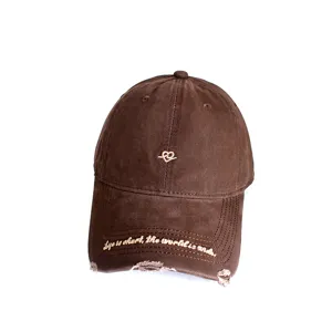Detailed view of vintage brown distressed baseball cap with heart embroidery and quote