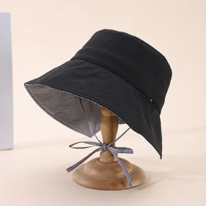 Vue de détail du chapeau bob noir avec doublure à carreaux et mentonnière ajustable.
