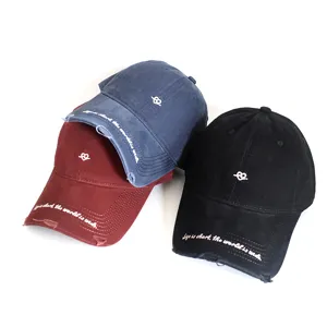 Close-up of three distressed baseball caps in navy, burgundy, and black with embroidery.