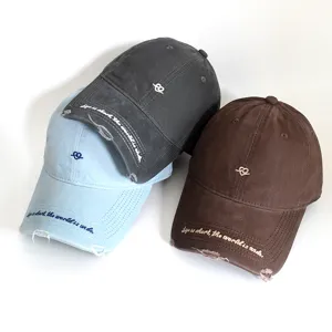 Detailed view of three distressed cotton baseball caps with embroidered slogans