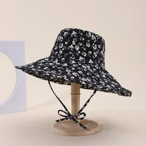 Detailed view of black and white floral print sun hat with wide brim and bow strap