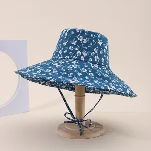 Blue floral wide brim bucket hat with adjustable strap on a wooden display stand
