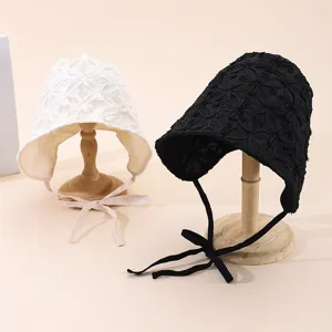 Vue détaillée de chapeaux de soleil en dentelle florale noire et blanche avec jolis liens élégants.