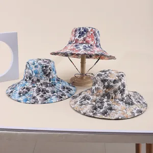 Detail shot of three stylish wide-brimmed sun hats with unique floral leaf patterns