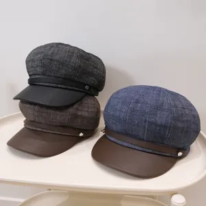 Collection of three retro British style newsboy caps in blue brown and grey on a white tray