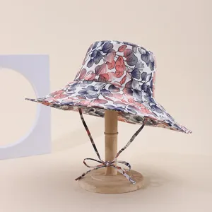 Side view detail of a wide brim floral print sun hat displayed on a wooden stand