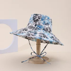Macro view of blue floral print sun hat with large brim on a wooden display stand