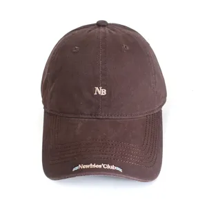 Brown baseball cap detail showing embroidered NB logo and brim lettering, casual style.
