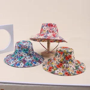 A group of three colorful floral print wide-brimmed sun hats for outdoor travel
