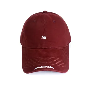 Closeup of a maroon baseball cap featuring white NB embroidery and brim text detail.