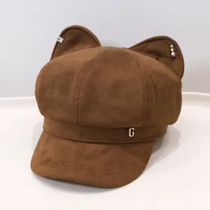 Detailed view of brown faux suede baker boy hat featuring cute cat ears and metal G letter.