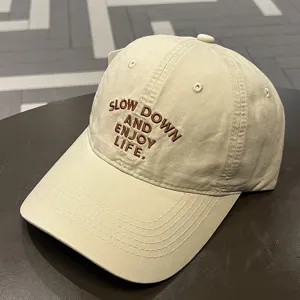Gorra de béisbol casual en beige con bordado de letras marrones, elegante y parasol.