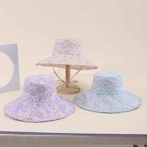 Detailed view of three floral print wide-brim sun hats in various pastel colors