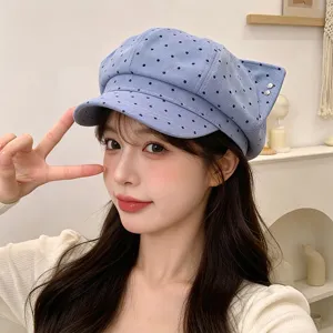 Detailed view of blue polka dot cat ear beret hat, stylish and cozy for autumn and winter.