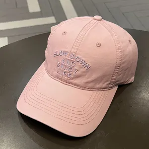 Vista detallada de la gorra de béisbol rosa con elegante bordado delantero y visera curva.