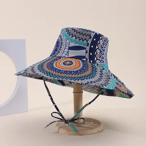 Detailed view of a wide-brimmed bucket hat with ethnic prints on a wooden stand