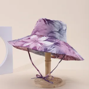 Macro view of purple floral print wide-brimmed sun hat on a wooden display stand