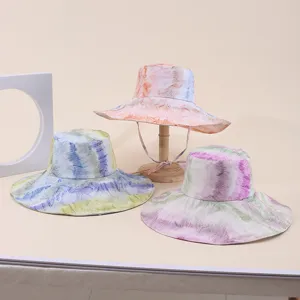 Detailed view of three marble print wide-brim sun hats with adjustable chin straps