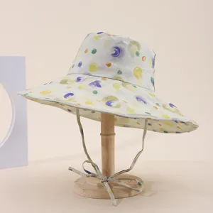 Detail view of a wide brim sun hat with colorful watercolor floral print on a wooden stand