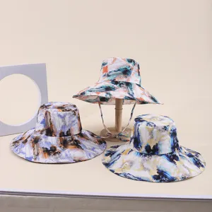 Detailed macro view of three wide-brimmed sun hats with vibrant abstract art prints on fabric