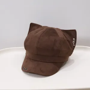 Close-up detail of the brown suede cat ear newsboy cap with metal key and eyelet decorations.
