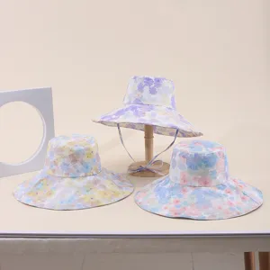 Detailed view of three floral print wide brim sun hats in purple, yellow and blue.