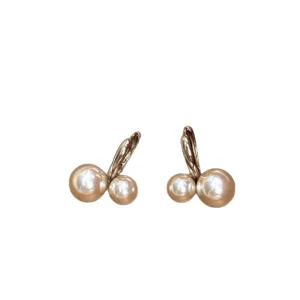 Detailed macro view of elegant double pearl cherry-shaped earrings with gold-toned finish
