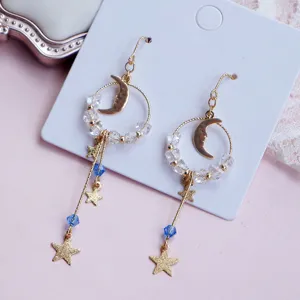 Vue détaillée de boucles d'oreilles asymétriques étoile et lune avec cristaux bleus