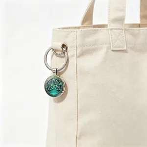 Portachiavi con cabochon in vetro a nodo celtico appeso a una borsa in tela beige